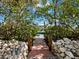 Walkway through lush landscaping to private dock at 598 Lyons Ln, Longboat Key, FL 34228