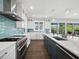 Modern kitchen with white cabinets, quartz countertops, and stainless steel appliances at 598 Lyons Ln, Longboat Key, FL 34228
