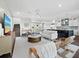Open living room with modern furniture, a large TV, and an adjacent kitchen at 598 Lyons Ln, Longboat Key, FL 34228