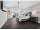 Bright bedroom with a king-size bed, dark wood furniture, and a wall-mounted TV at 598 Lyons Ln, Longboat Key, FL 34228