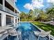Relaxing pool area with lounge chairs and lush landscaping at 598 Lyons Ln, Longboat Key, FL 34228