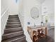 Modern staircase with dark wood steps and a glass-topped console table at 598 Lyons Ln, Longboat Key, FL 34228