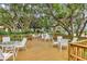 Community deck with white tables and chairs under shade trees at 6615 Hunter Combe Xing, University Park, FL 34201