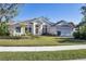 House exterior showcases a light-colored facade, tile roof, and manicured lawn at 6615 Hunter Combe Xing, University Park, FL 34201