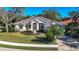 Single-story home with tile roof, light beige exterior, and lush landscaping at 6615 Hunter Combe Xing, University Park, FL 34201