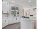 Newly remodeled kitchen boasts white cabinets, a large island, and a gas cooktop at 6615 Hunter Combe Xing, University Park, FL 34201