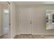 Bright entryway with wood-look tile floor, white door, and view into adjacent room at 1002 Hagle Park Rd, Bradenton, FL 34212