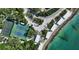 An aerial view of tennis courts, beach pavilions, and turquoise waterfront at 1249 S Basin Ln, Sarasota, FL 34242