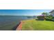Lush green lawn extending to the waterfront, complete with a private dock and vibrant flowering shrubs at 1249 S Basin Ln, Sarasota, FL 34242