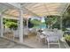 Relaxing covered patio with tables and chairs near tennis courts at 1249 S Basin Ln, Sarasota, FL 34242