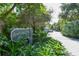 Sanderling Club entrance with lush landscaping and privacy gate for a secure community at 1249 S Basin Ln, Sarasota, FL 34242