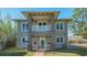 Elegant two-story home with a charming balcony, brick accents, and lush landscaping at 1249 S Basin Ln, Sarasota, FL 34242