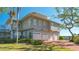 Gray house with three-car garage and brick driveway at 1249 S Basin Ln, Sarasota, FL 34242