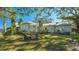 Gray house with white trim, large trees, and a waterfront view at 1249 S Basin Ln, Sarasota, FL 34242