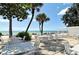 Relaxing patio with tables, chairs, and a scenic view of the ocean and white sand beach at 1249 S Basin Ln, Sarasota, FL 34242