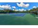 Well-maintained tennis courts surrounded by lush greenery and mature trees at 1249 S Basin Ln, Sarasota, FL 34242