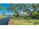 Landscaped waterfront property with brick walkway and mature trees at 1249 S Basin Ln, Sarasota, FL 34242