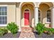 Red front door entry with columns and landscaping at 17113 1St E Dr, Bradenton, FL 34212