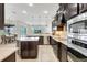 Open concept kitchen with dark cabinetry, granite countertops, and stainless steel appliances at 17113 1St E Dr, Bradenton, FL 34212