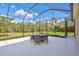 Outdoor patio with table and chairs, screened enclosure, and view of the backyard at 17113 1St E Dr, Bradenton, FL 34212