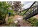 Landscaped backyard with a wooden staircase and small table at 1720 Glenhouse Dr # 330, Sarasota, FL 34231