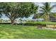 Landscaped area with a bench overlooking a peaceful waterfront at 1800 Cove Ii Pl # 213, Sarasota, FL 34242