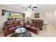 Living room with brown leather sofas, and a view into the dining area at 20207 Gladstone Ave, Port Charlotte, FL 33952