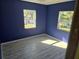 Charming bedroom with blue walls, two windows, and light gray flooring at 21459 Olean Blvd, Port Charlotte, FL 33952