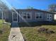 Newly renovated house exterior with gray siding and a walkway at 21459 Olean Blvd, Port Charlotte, FL 33952