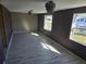 Spacious living room with new gray vinyl plank flooring and dark purple walls at 21459 Olean Blvd, Port Charlotte, FL 33952