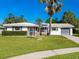 White ranch house with a lush lawn and palm tree in front at 3158 Regatta Cir, Sarasota, FL 34231