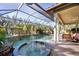 Inviting pool area with covered patio, spa, and comfortable seating at 3706 80Th E Dr, Sarasota, FL 34243