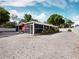 Property exterior showing a red building and gravel parking area at 3825 Sarasota Golf Club Blvd, Sarasota, FL 34240