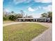 Ranch style home with a metal roof and circular driveway at 3825 Sarasota Golf Club Blvd, Sarasota, FL 34240