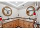 Bathroom with double vanity, large mirrors, and light wood cabinets at 3856 Trophy Blvd # 2, New Port Richey, FL 34655