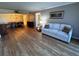 Open living area with wood floors, a sofa, and views into the dining room at 4119 61St Avenue W Ter # 308, Bradenton, FL 34210