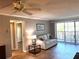 Bright living room with hardwood floors, comfy sofa, and sliding glass doors to balcony at 4119 61St Avenue W Ter # 308, Bradenton, FL 34210
