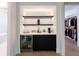 Modern wet bar with floating shelves, mini-fridge, and sleek cabinetry at 4213 W Culbreath Ave, Tampa, FL 33609