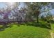 Large backyard with lush green grass, mature trees, and a white vinyl fence at 4316 Callista Ln, Sarasota, FL 34243