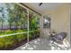 Relaxing screened porch with a seating area overlooking a lush backyard with mature trees at 4316 Callista Ln, Sarasota, FL 34243