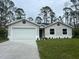 Newly built home with a white garage door and landscaping at 5274 Neon Ave, North Port, FL 34291