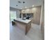 Modern kitchen featuring sleek cabinets, a center island with seating, and stainless steel appliances at 5274 Neon Ave, North Port, FL 34291