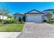 One-story home with gray siding, white garage door, and a paved driveway at 6043 Bluestar Ct, Bradenton, FL 34211