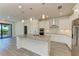 Modern kitchen with granite island, stainless steel appliances, and white cabinets at 6043 Bluestar Ct, Bradenton, FL 34211