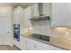 White kitchen cabinets with granite countertops and a stainless steel range hood at 6043 Bluestar Ct, Bradenton, FL 34211