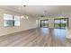 Spacious living room with wood-look floors and sliding doors to the pool at 6043 Bluestar Ct, Bradenton, FL 34211