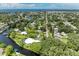 A stunning aerial view shows the canal-front house with private pool and verdant trees in a picturesque neighborhood at 608 69Th W Ave, Bradenton, FL 34207