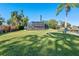 Expansive backyard showcasing a large lawn and screened pool area at 608 69Th W Ave, Bradenton, FL 34207