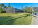Large backyard with screened enclosure, lush lawn, and canal access at 608 69Th W Ave, Bradenton, FL 34207