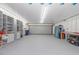Spacious garage with ample storage shelving and large roll-up door at 608 69Th W Ave, Bradenton, FL 34207